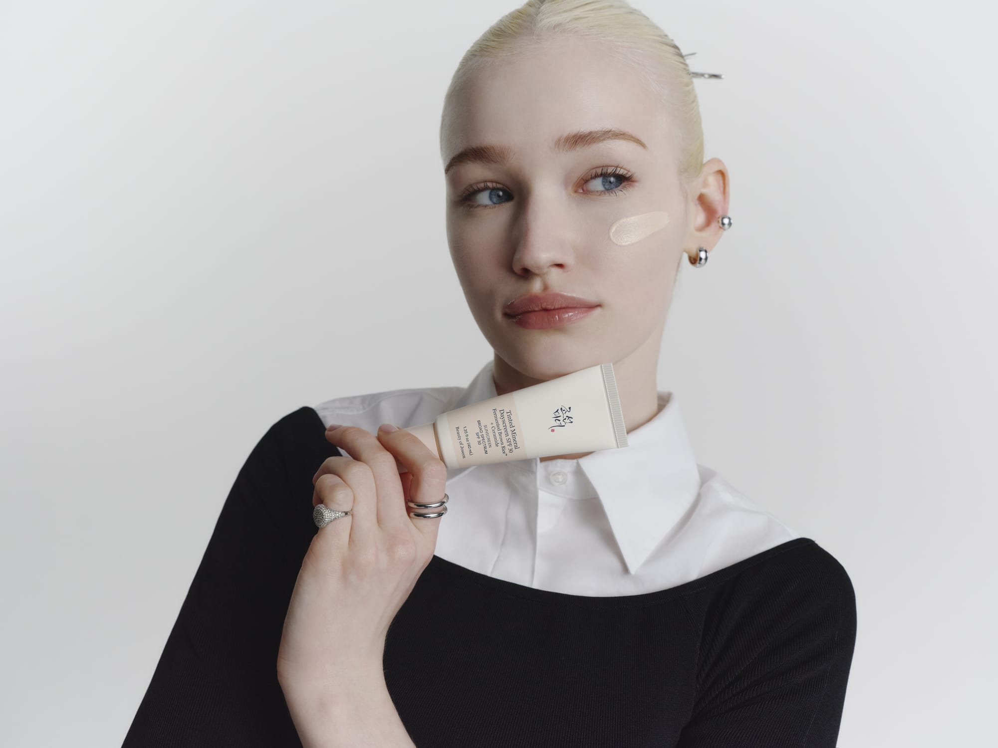 A model holding a Tinted Mineral Dayscreen product.