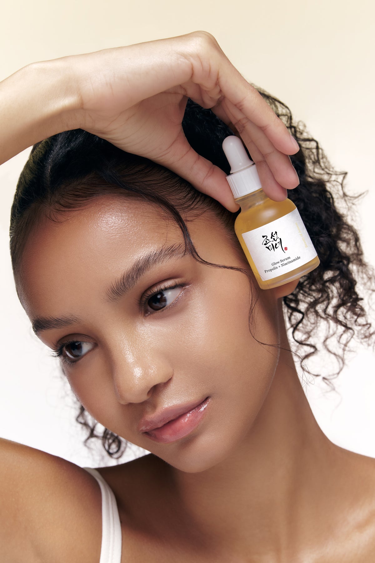a woman holding a small bottle of oil
