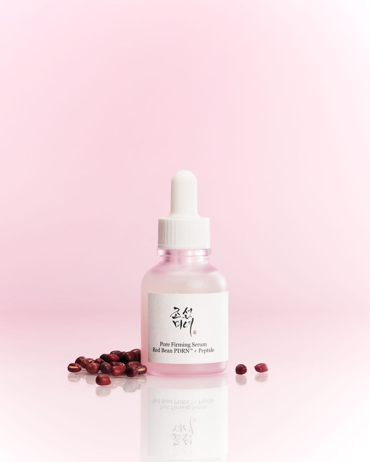 Skincare serum bottle with dropper on a pink background