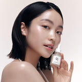 a woman holding a small bottle of liquid