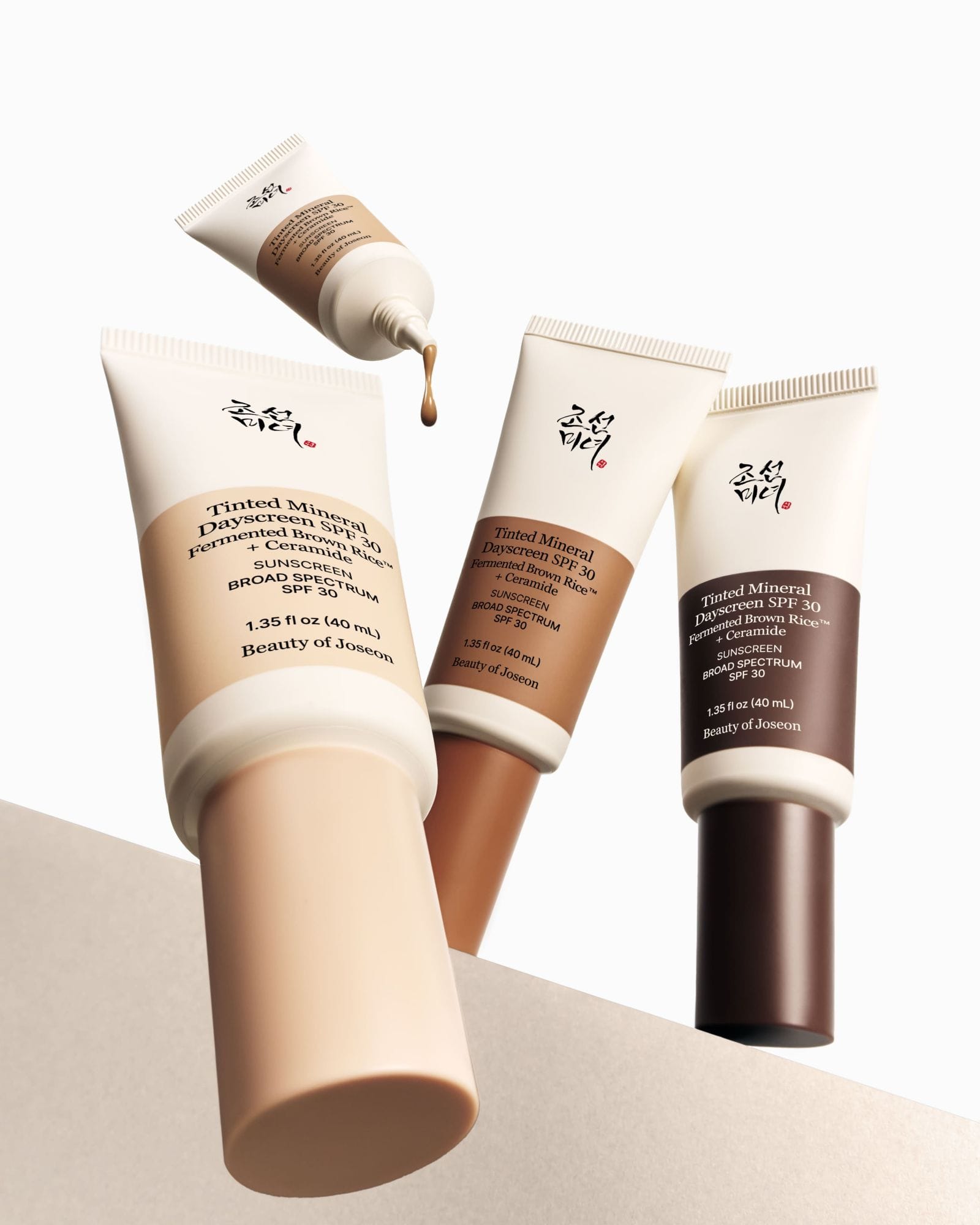 Three tubes of Beauty of Joseon Tinted Mineral Dayscreen foundation on a beige background
