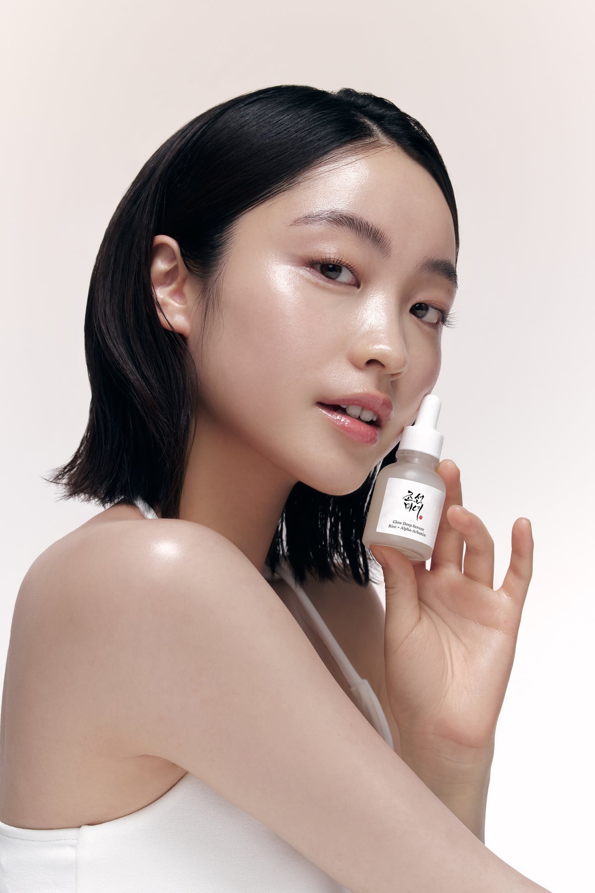a woman holding a small bottle of liquid